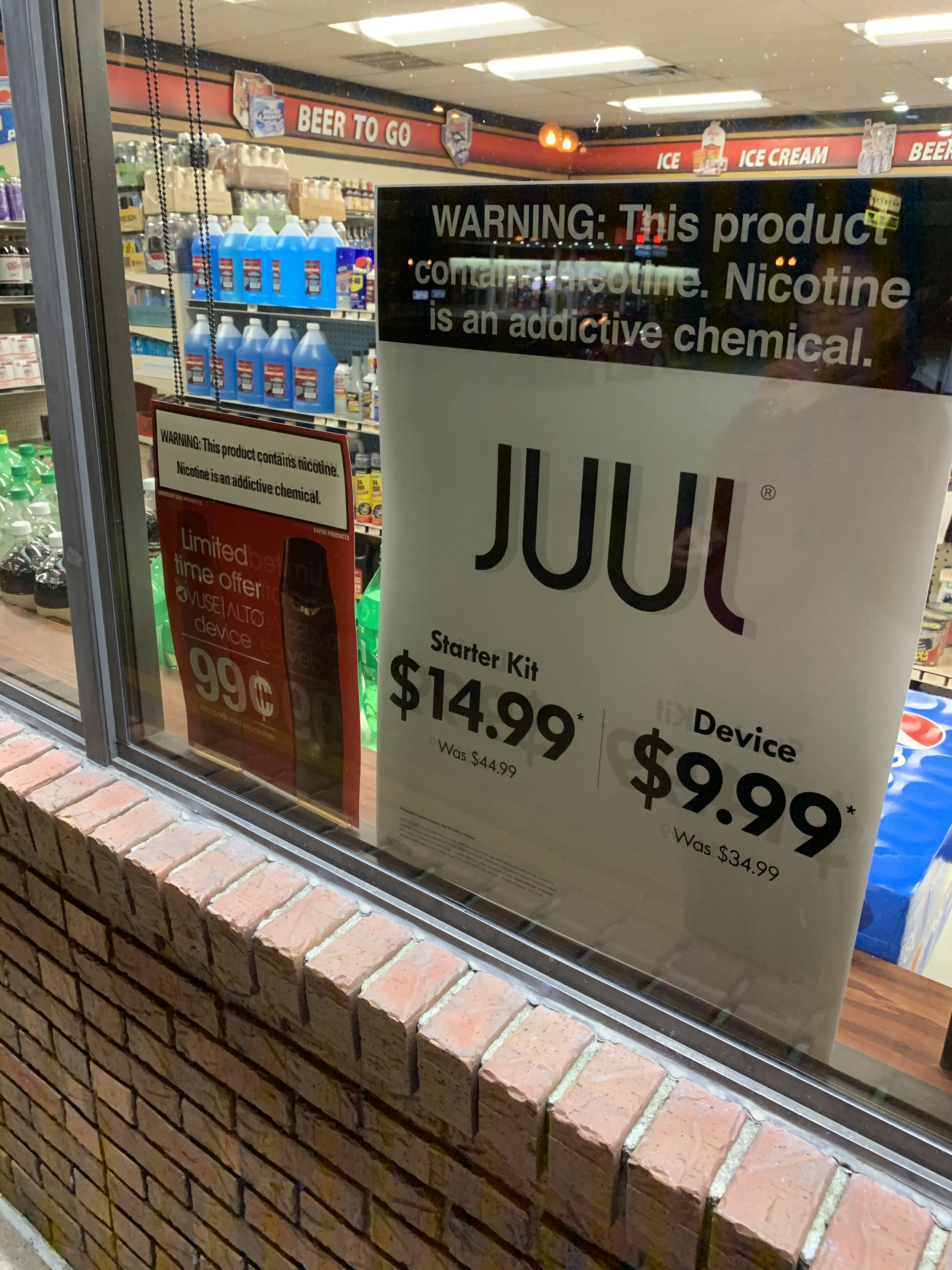 ads for Juul and Vuse in a retailer window