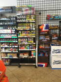 Rack of little cigars/chewing tobacco next to a display for candy