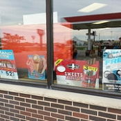 Store window display of ice cream and tobacco ads