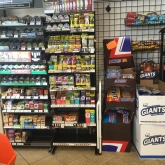 Rack of little cigars/chewing tobacco next to a display for candy