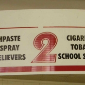 Small Grocer Aisle Sign Selling Tobacco-Related Product near School Supplies
