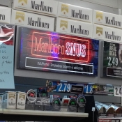 Tobacco advertisements and price discounts near the register.