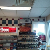 This Marlboro Ad was behind the counter placed about a store's ad for pizza.