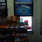 Tobacco price placard behind candy rack.