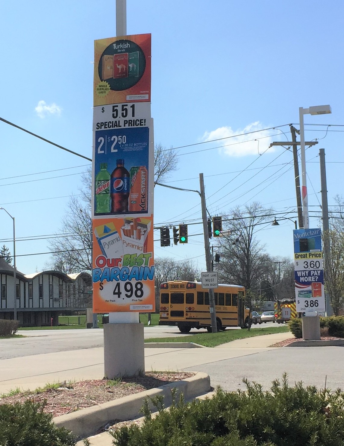 cigarette ads on a lightpole next to the road on a school bus route