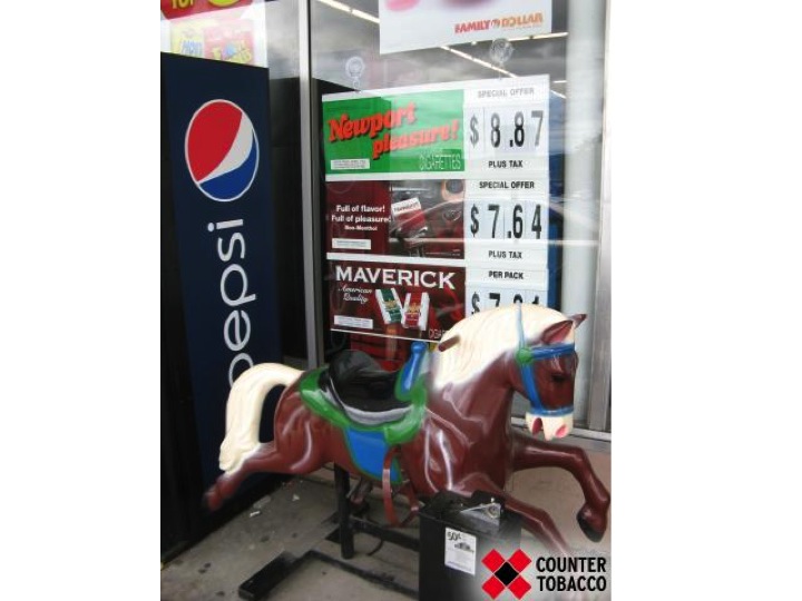Slide 3 - horse riding toy in front of cigarette ads 