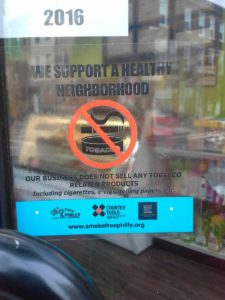 Sign on retailer's window: "We Support a Healthy Neighborhood. Our business does not sell any tobacco related products"